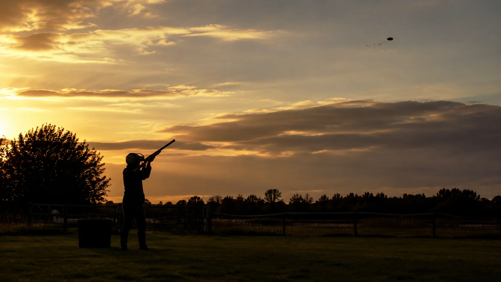 A shooter on a clay ground in warm evening light